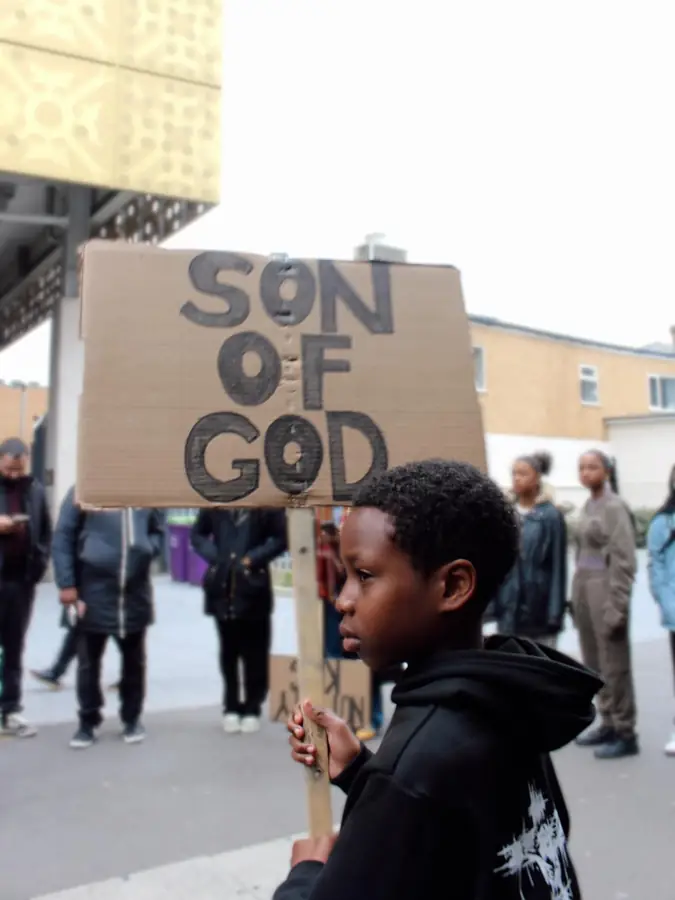 A boy holding a Son of God placard at a street outreach